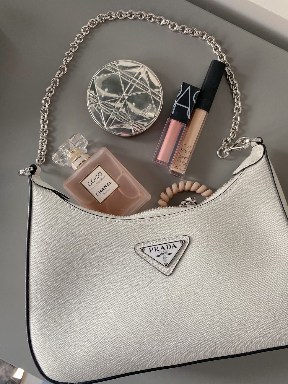 flatlay shot of a bag with makeup and perfume